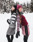 two friends laughing in the snow wearing skhoop outfits