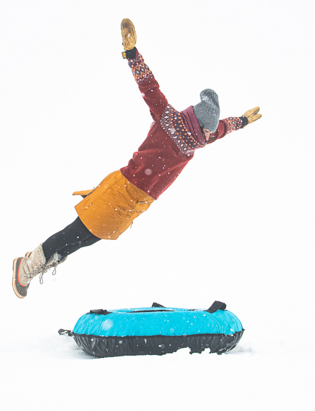 woman jumping into a sled wearing skhoop sandy skirt