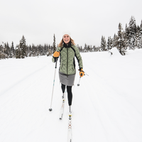woman xc skiing wearing a puffy skhoop jacket and skirt