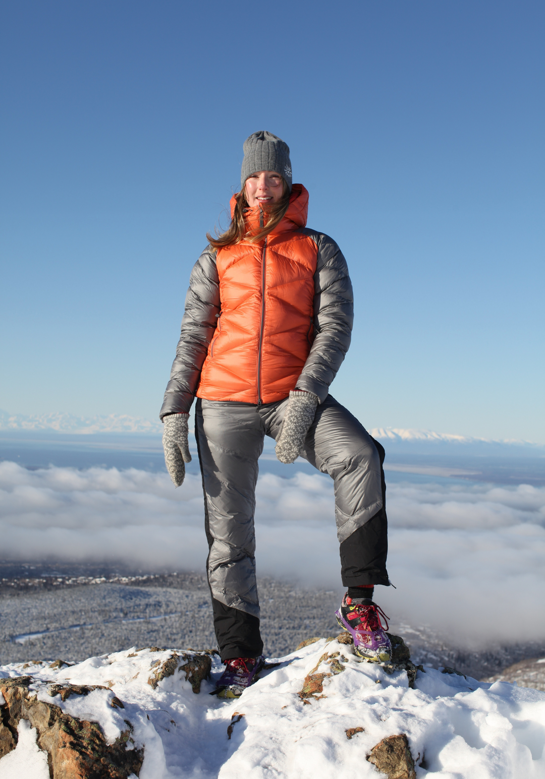 woman on top of a snowy mountain wearing skhoop daria puffy down pants