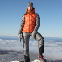 woman on top of a snowy mountain wearing skhoop daria puffy down pants