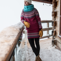woman standing on snowy deck in skhoop wool sweater and skirt