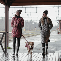two women walking their dog wearing skhoop quilted down parka