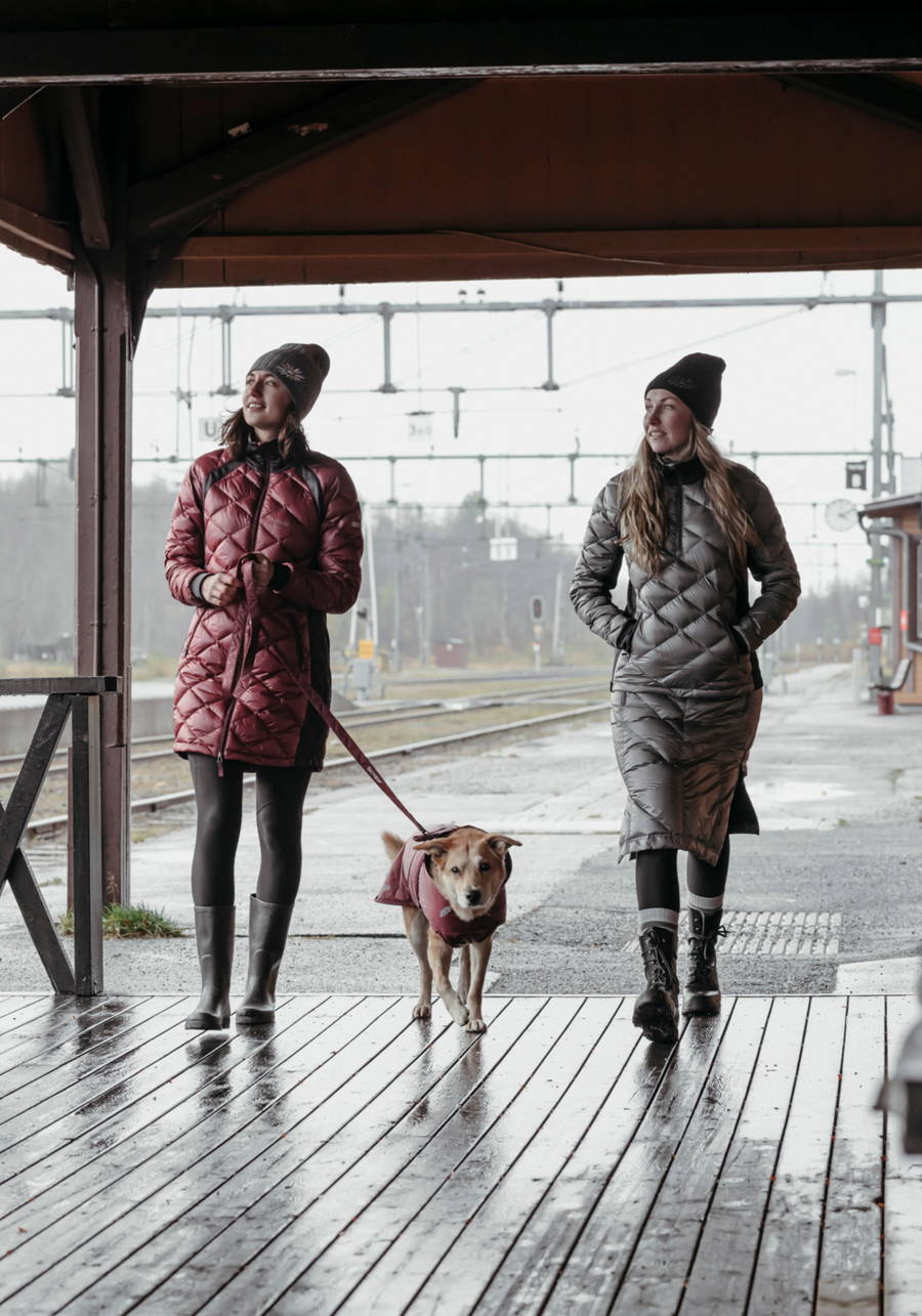 two women walking their dog wearing skhoop quilted down parka