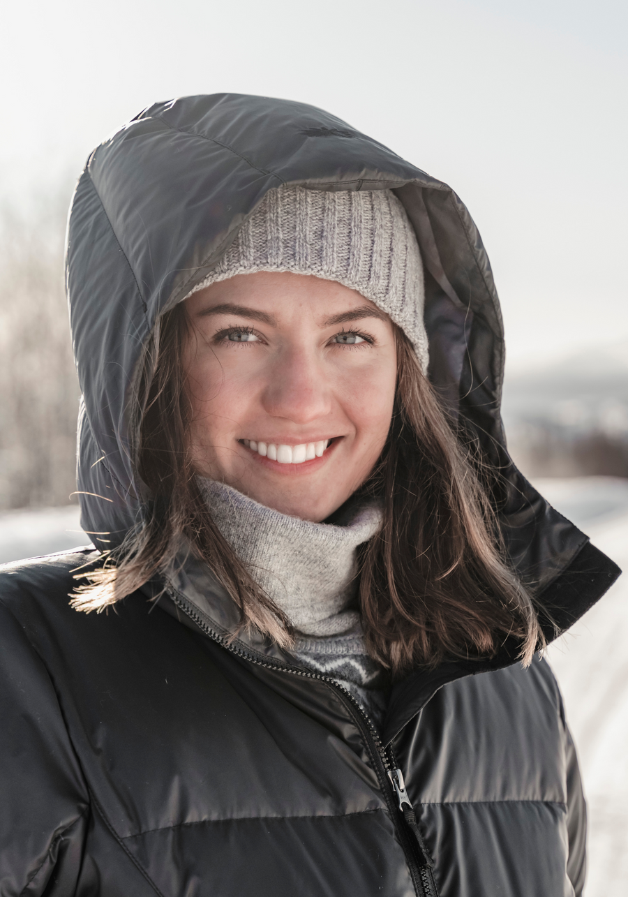 woman smiling on a cold winter day with her puffy down hood keeping her warm