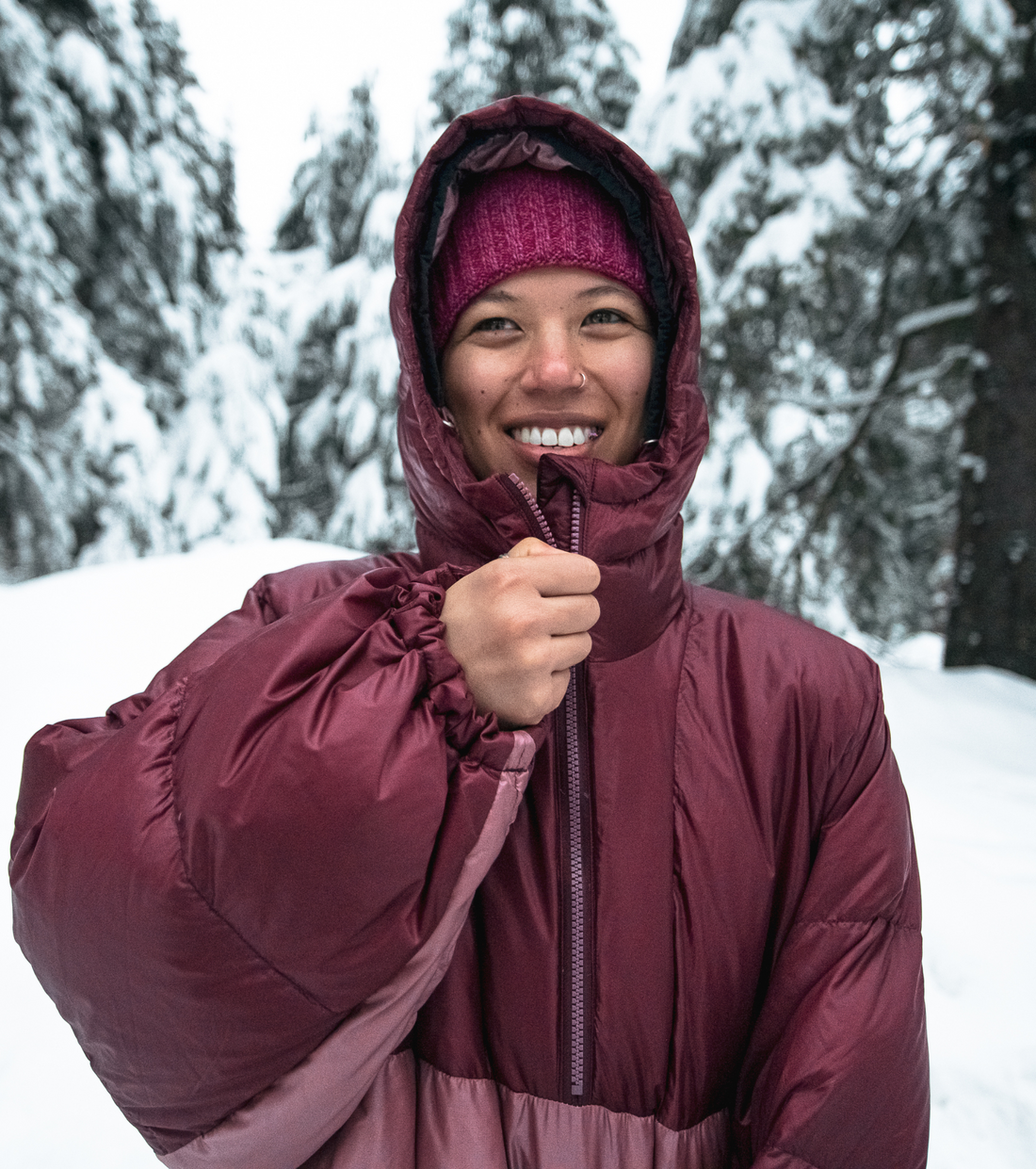woman smiling as she zips up her skhoop pia down poncho