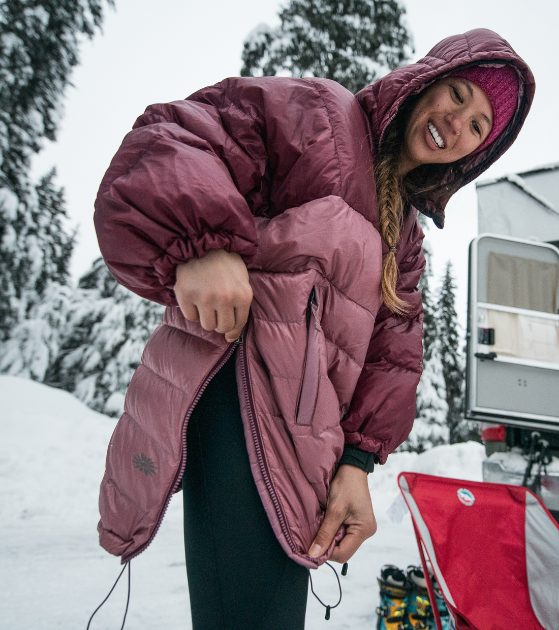 woman using the side zipper on her skhoop pia down poncho