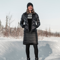 woman standing in the snow wearing black skhoop short down skirt
